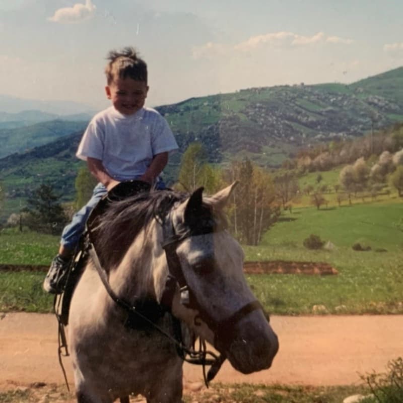 Amar as a kid riding a horse in the hills